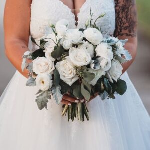 A closeup shot of the bride in wedding gown holding a bouquet