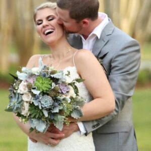 A picture of the groom kissing on the brides cheeks